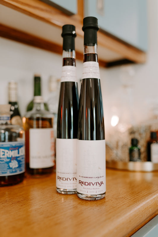 Two Bottles of Blackberry Liqueur on a Bar.